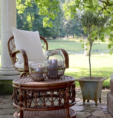 Foto av somrig veranda med rottingmöbler och grönska