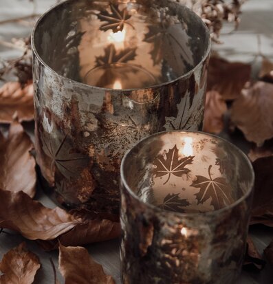 Bild av ljuslykta med höstlöv och stämningsfullt ljus