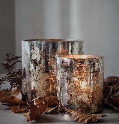 Bild av ljuslyktor med höstlöv och varm atmosfär