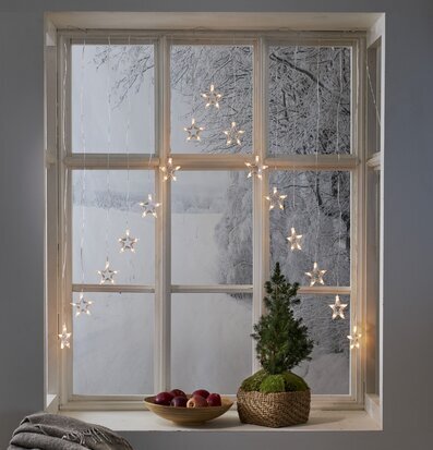 Bild av mysigt fönster med ljusgardin och vinterlandskap