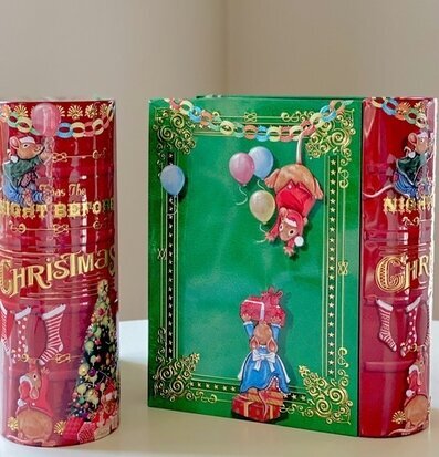 Bild av plåtburk som liknar en bok med julmotiv