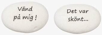 Bild av två vita stenar med humoristiska inskriptioner