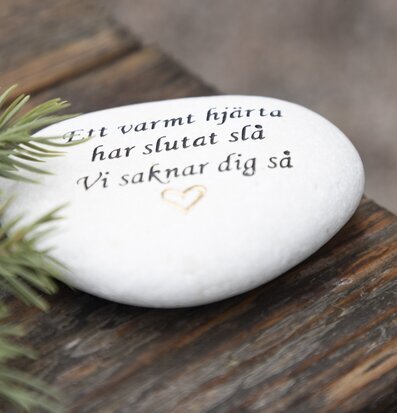 Bild av graverad vit sten med känslosamt budskap