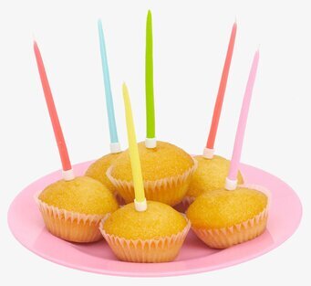 Bild av färgglada muffins med festliga ljus på rosa fat