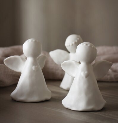 Bild av tre små änglastatyetter i harmonisk komposition