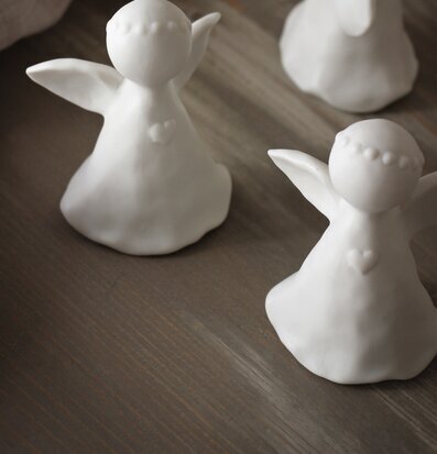 Bild av tre stilrena ängelfigurer i vit keramik