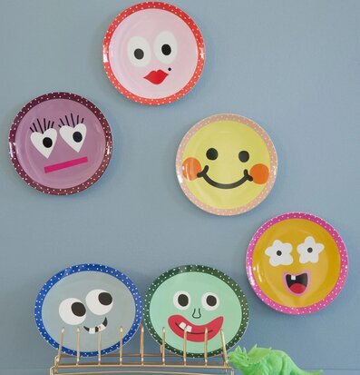 Foto av färgglada tallrikar med lekfulla ansiktsmotiv
