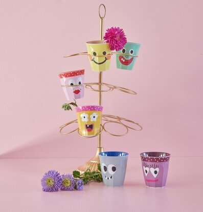 Bild av lekfulla muggar med ansikten på ställning