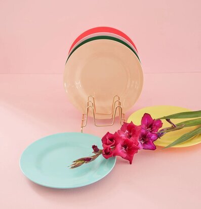 Bild av färgglada tallrikar med blommor i förgrunden