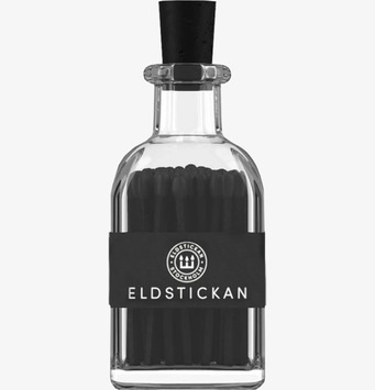 Bild av elegant glasbehållare med mörka tändstickor