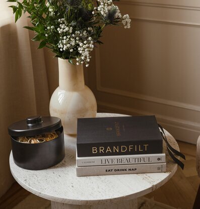 Foto av smakfullt arrangerat bord med blommor och böcker