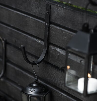 Foto av stilren krok och lykta i rustik miljö