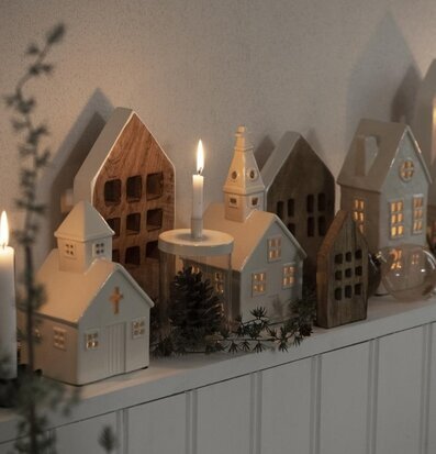 Bild av dekorativa trähus i vintrig och varm miljö