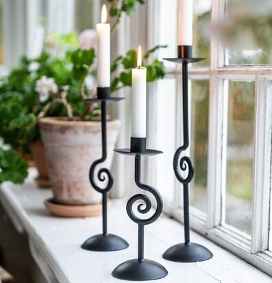 Foto av stilrena ljusstakar på fönsterbräda med växter