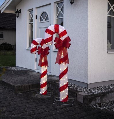 Foto av juldekorationer vid husentré med polkagrisstänger