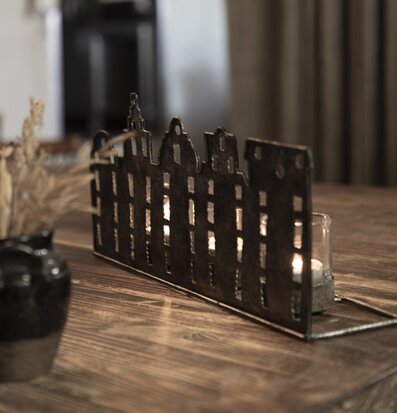 Bild av ljuslykta i metall med stadssilhuett-design