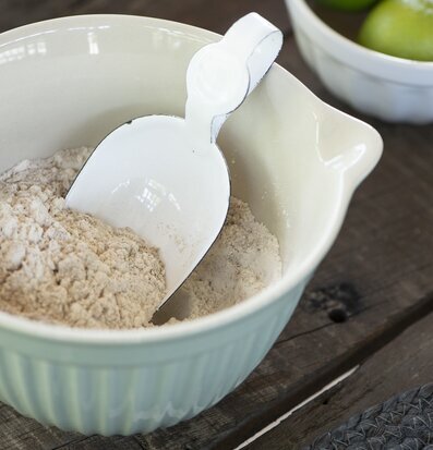 Bild av elegant grön vispskål med mjöl och skopa