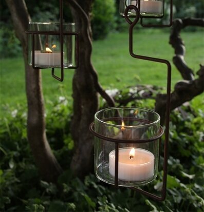 Bild av hängande ljuslyktor i en lummig trädgård