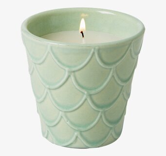 Bild av ljus i grön keramikbehållare med reliefmönster