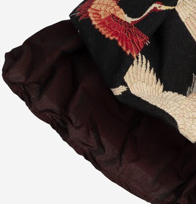 Bild av bordslampa med broderade tranor i fokus