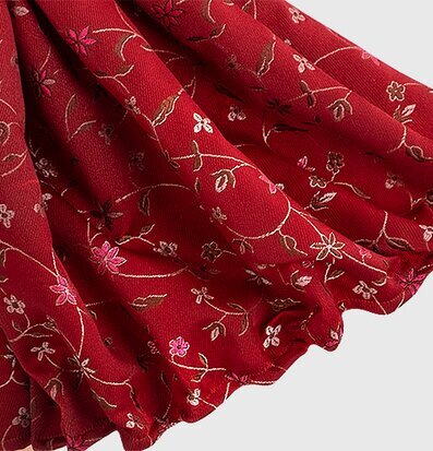 Bild av röd textil med blommor och slingrande rankor