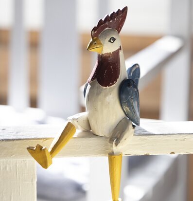 Bild av lekfull, ledad träfigur föreställande tupp