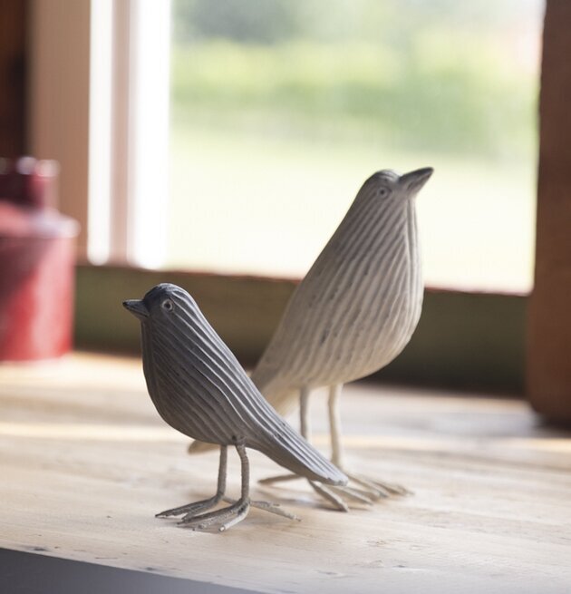 Bild av dekorativa träfåglar på ljus yta nära fönster