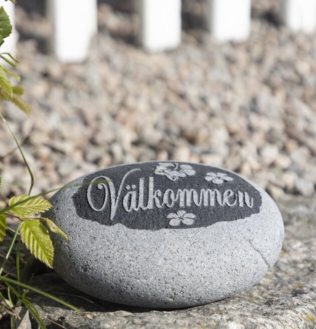 Bild av dekorativ trädgårdssten med välkomsttext