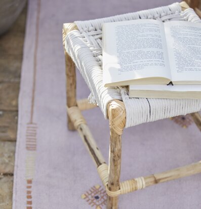 Bild av charmig scen med handflätad pall och matta