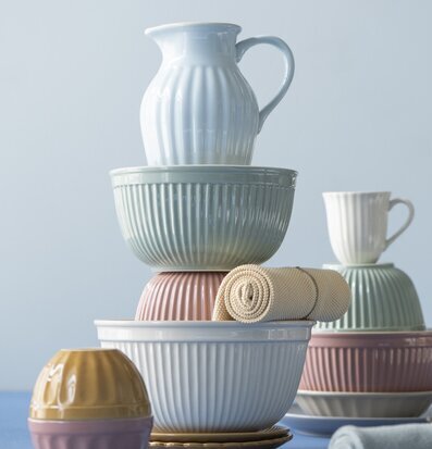 Bild av harmoniskt arrangerat keramikset i pastellfärger