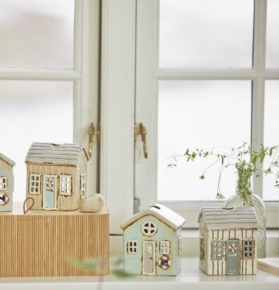 Foto av ljuslyktor på fönsterbräda med blommor