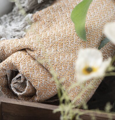 Bild av en mjuk och inbjudande pläd i kräm och gult