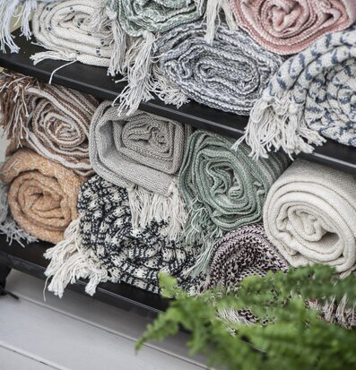 Bild av färgglada plädar i en harmonisk butiksmiljö