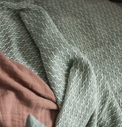 Bild av skandinavisk textil i krämiga och gröna toner