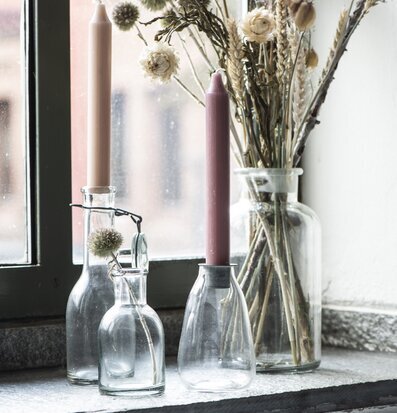 Bild av hemtrevlig fönsterbräde med ljus och blommor