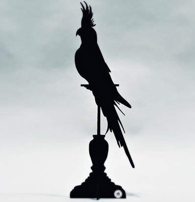 Bild av stilren svart papegoja i plåt på piedestal