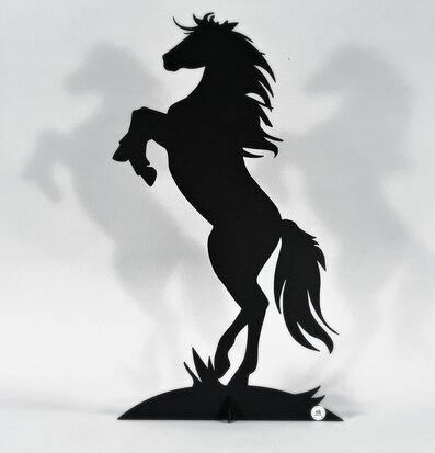 Bild av imponerande svart metallhäst i silhuett