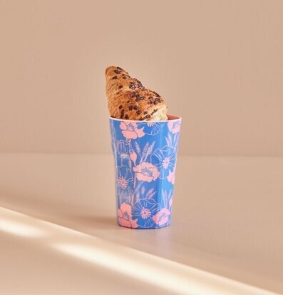 Bild av stilren mugg med blommönster och croissant