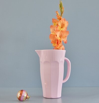 Bild av rosa kanna med blomma och glittrande dekoration