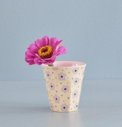 Bild av mugg med blommor och hjärtan på grå yta