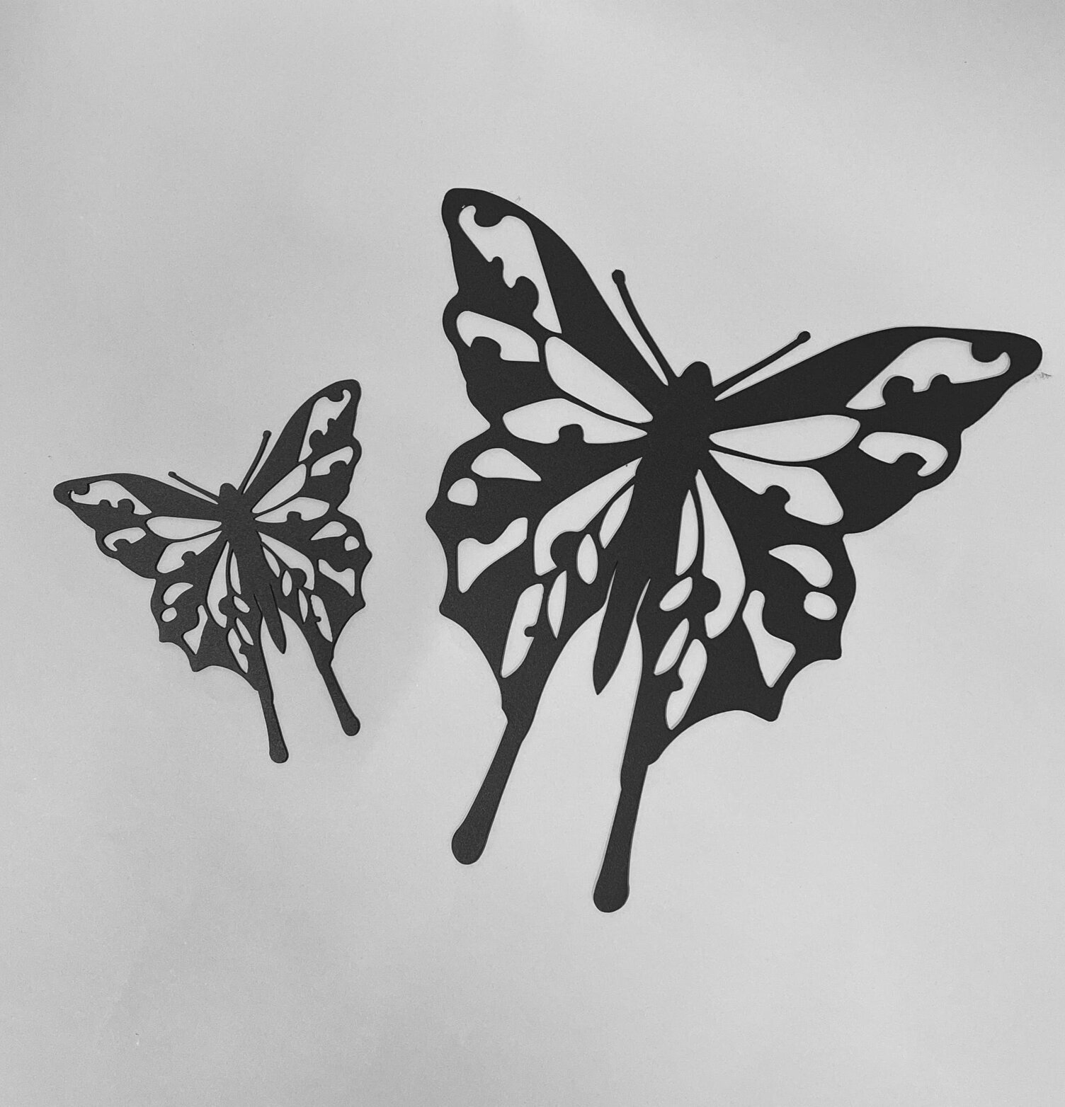 Bild av stilrena fjärilar i svart metallhantverk