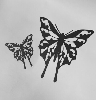 Bild av stilrena fjärilar i svart metallhantverk