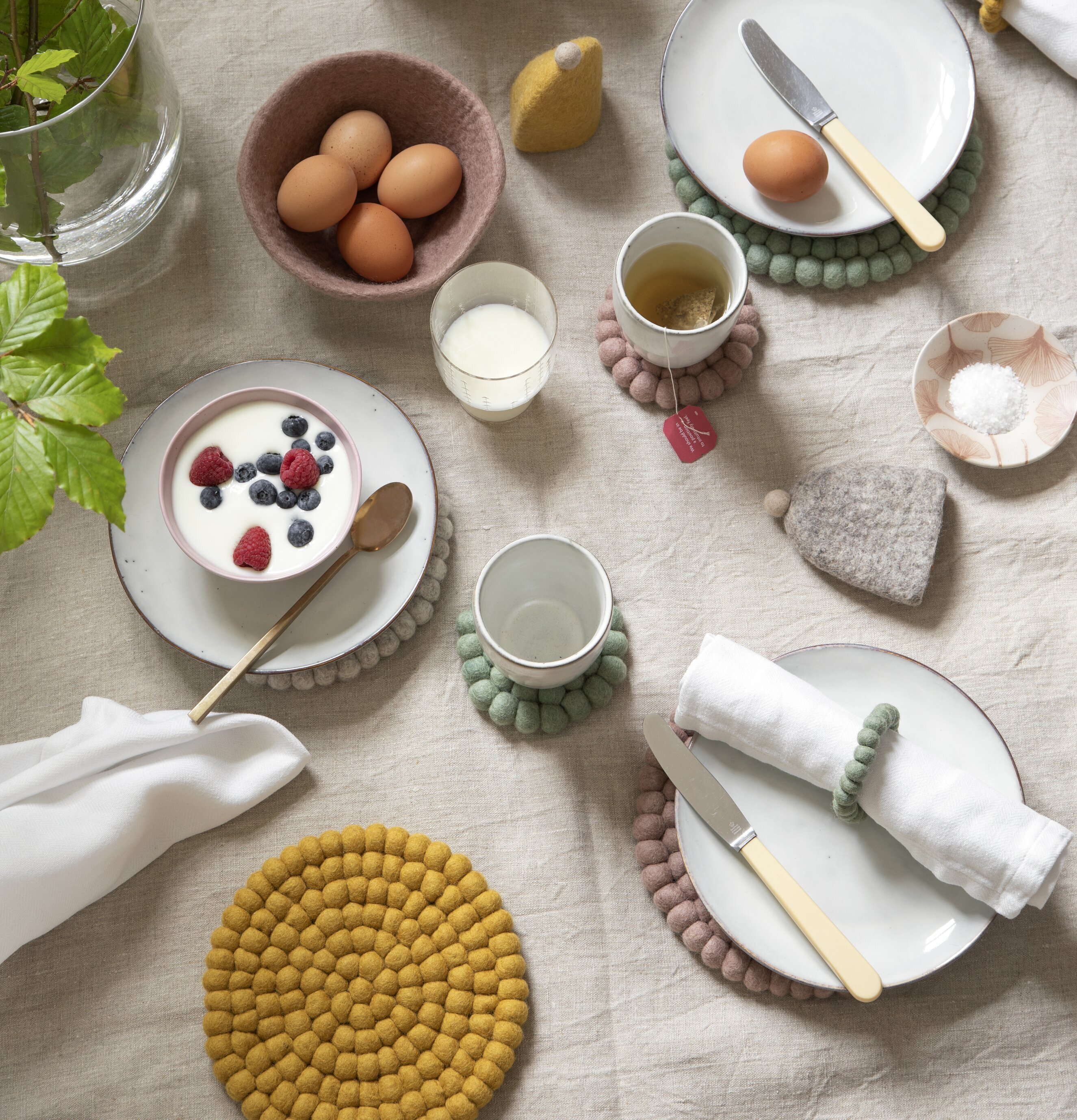 Grytunderlägg Tovad Ull - Ochre från Gry & Sif på dukat bord