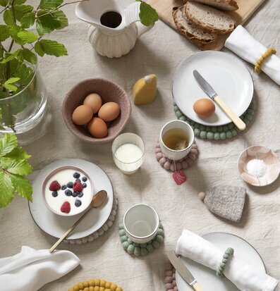 Bild av harmoniskt dukat bord med naturmaterial