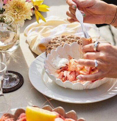 Bild av somrig måltid med räkor och blommor