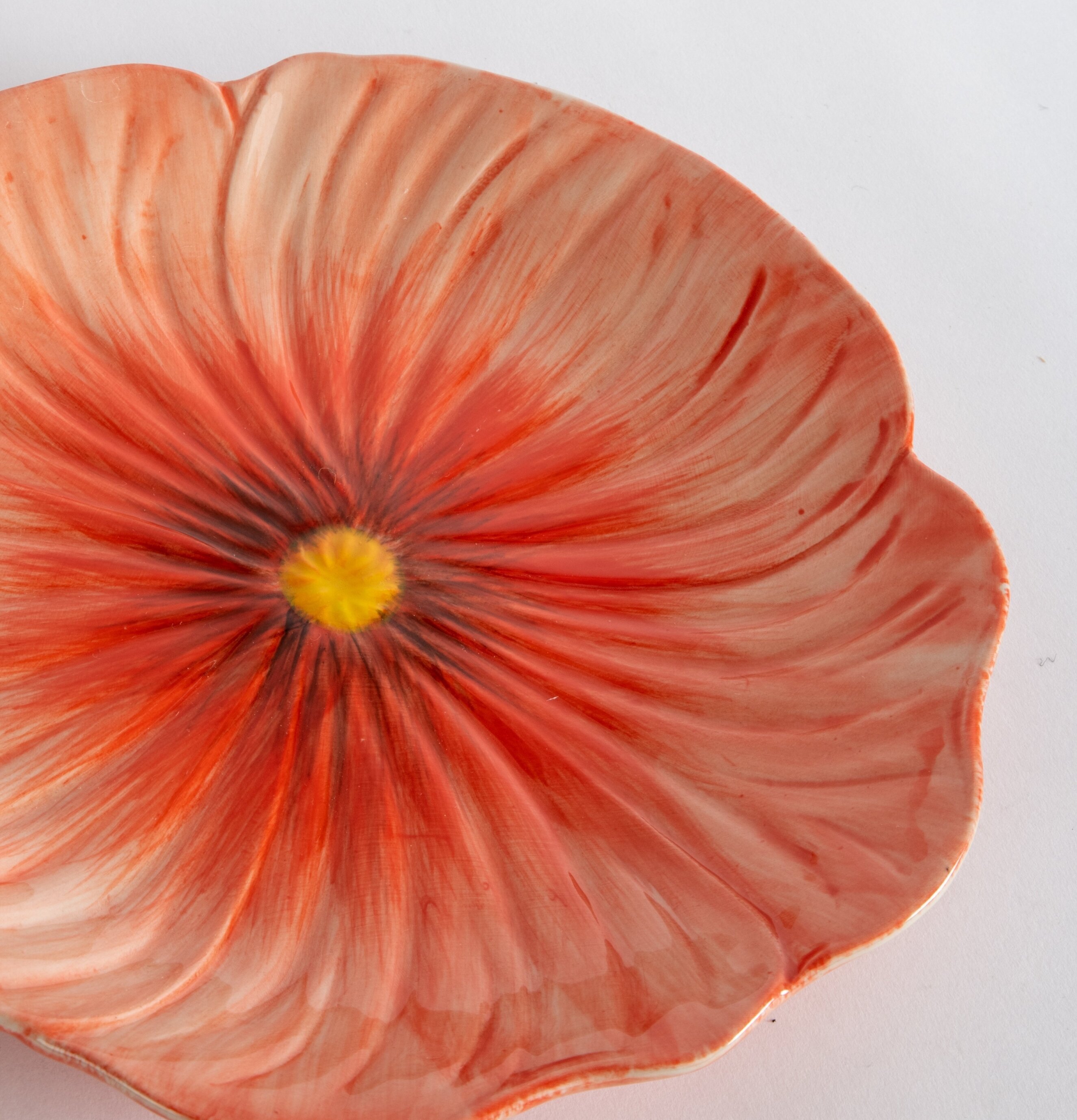 Bild av en röd assiett med blomdesign och glansig yta