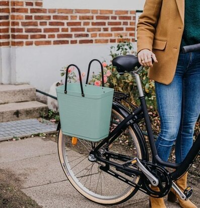 Bild av cykel med elegant väska i trädgårdsmiljö