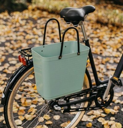 Bild av cykel med stilren väska på höstlövstäckt väg