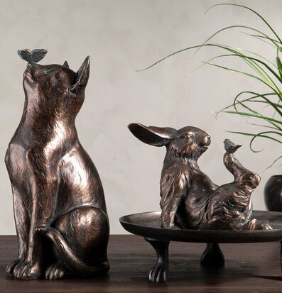 Bild av skulpturer: hund med fjäril och hare i skål