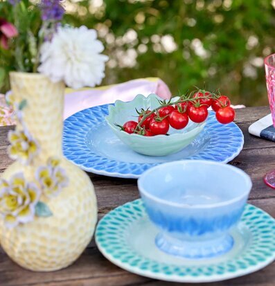 Bild av färgglad utomhusmiljö med keramik och blommor